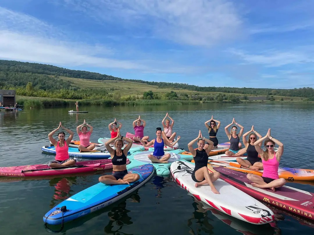 Skupinová jóga na paddleboardech na jezeře Milada